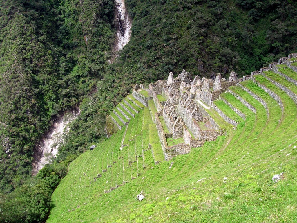 Could you build a home on a hillside? Best Hikes In Peru Image: The hillside has the remnants of old stone buildings; they form peaks but are missing roofs.