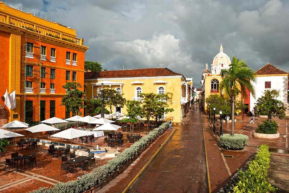 Ooh! Likes like there's a lovely little spot offering outdoor dining! Destinations Worth Dreaming Image: A city view shows a variety of architecture, and outdoor dining set up at one of the buildings we're looking at.