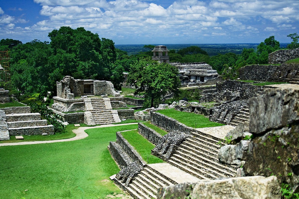 One can't help but notice the landscaping. Was that really part of the original design of this ancient city? Central and South American Ruins Image: Belize's ancient city is a series of timeworn and muted greys, juxtaposed by green lawns, and jungle trees. A blue sky and white clouds complete the scene.
