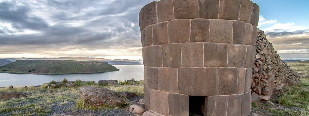 This would also be a lovely place to go visit one's deceased. This isn't nearly as scary as the cemeteries one usually thinks of. Best Hikes In Peru Image: Photograph of a funerary tower with an opening; this particular tower is overlooking the water.