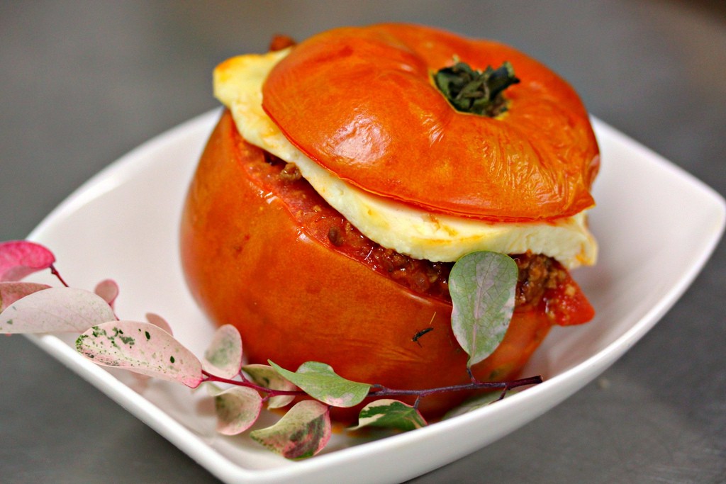 Mmm...let's take the top off and dig in! Visit Peru Image: A red rocoto pepper sits on a white dish. The cap of the pepper was cut off, and has been placed back on top of the filled pepper and cheese.