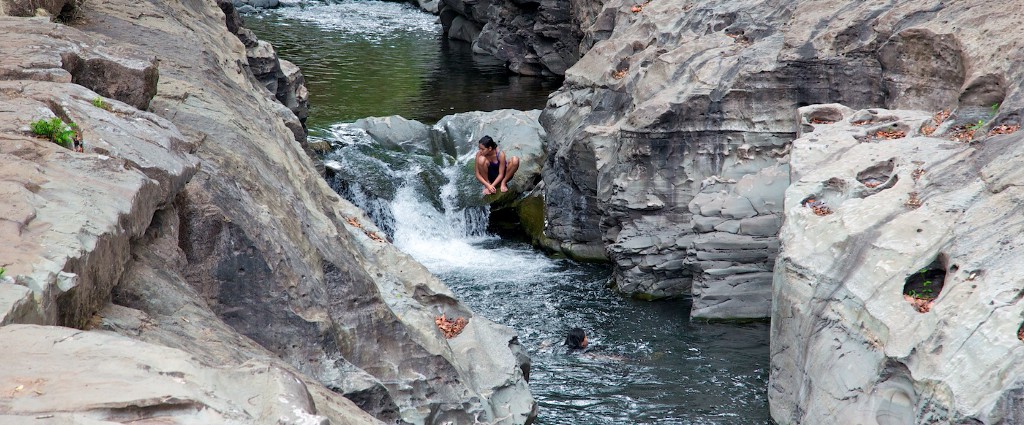 Warm up by taking an impromptu climb, then take a nice cool dip. Swimming Holes Image: People perch amongst the boulders and enjoy the cool waters of this Panamanian swimming hole.