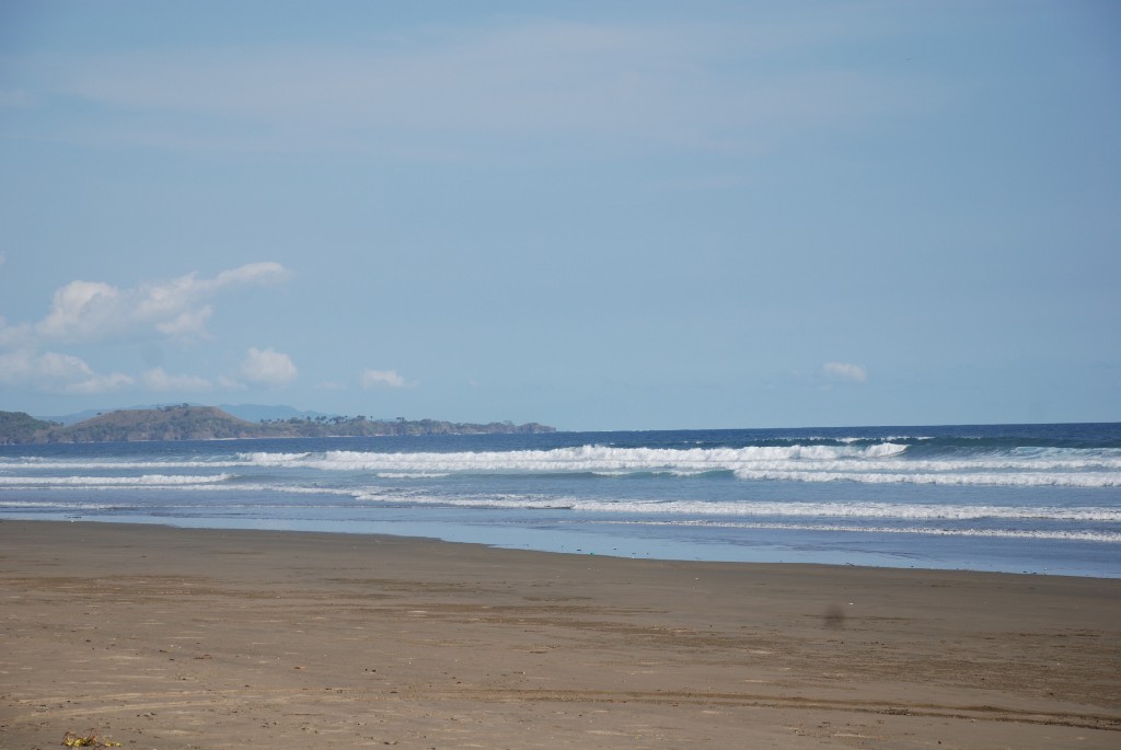 Primo! Best Surfing Beaches: The beach is empty, and waves are cresting highly as they roll in.