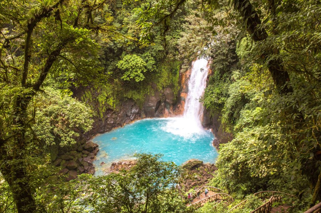 It's hard to top nature's swimming pools. Swimming Holes Image: A waterfall int he midst of a jungle gloriously empties itself into crater of turquoise water below.