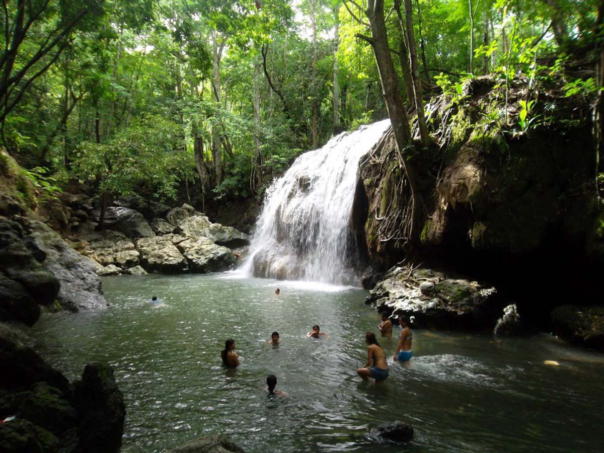 Whether cool or warm, the best vacations seem to have an abundance of natural water features. Hot Springs Image: Aguas Calientes Peru. People are enjoying soaking and swimming around in water as a small waterfall pours in.