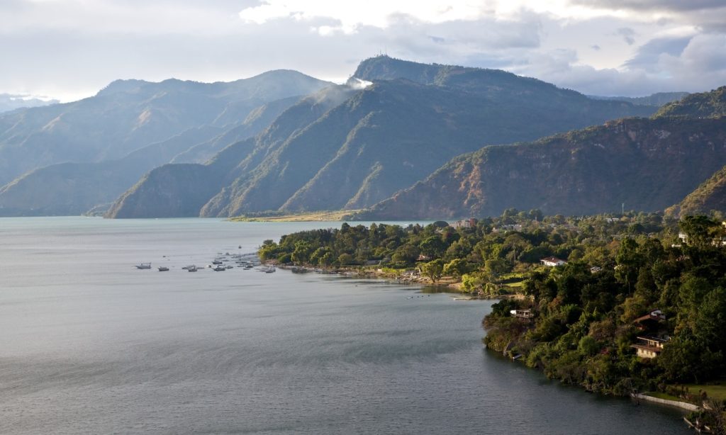 How far would you go to see this for yourself? Guatemala Dream Vacation Image: The brown mountains and green shores of Panajachel, Guatemala line Lake Atitlán.