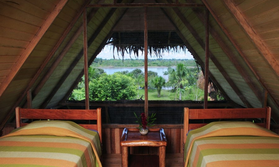 The construction of the lodge itself is as beautiful as the view. Peruvian Amazon Image: A suite with two beds at the Pacaya Samiria Lodge. We see an incredible view of the Amazon Rainforest.