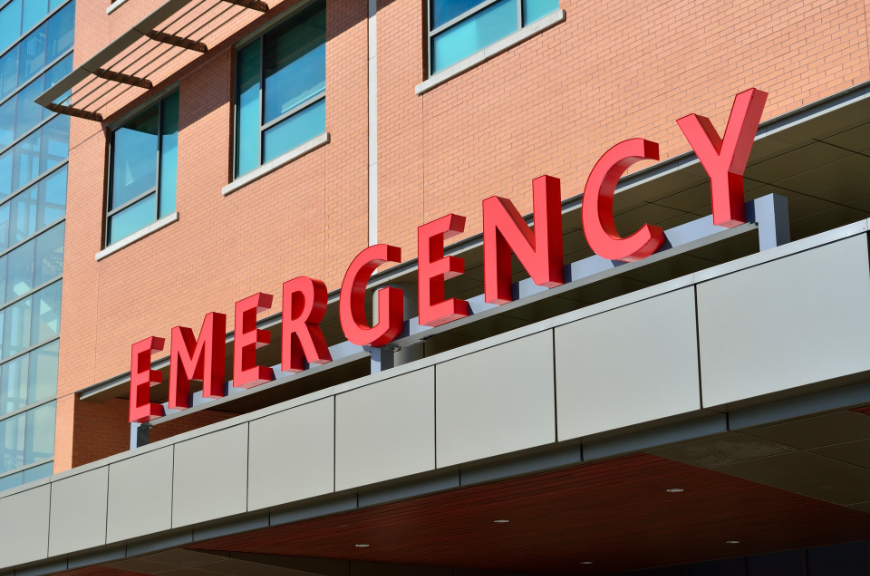 A red 'emergency' sign on a red brick building. Altitude Sickness Image: A red 'emergency' sign on a red brick building.