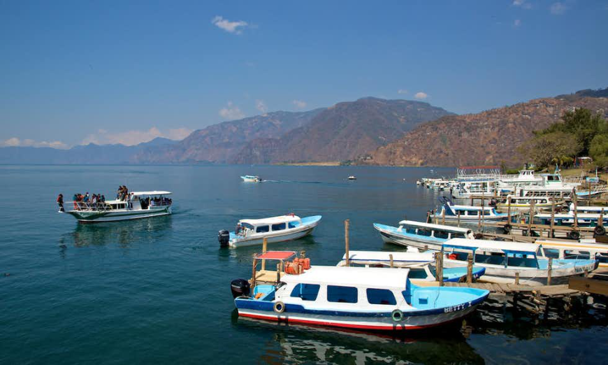 All aboard for a ride across Lake Atitlán! Belize and Guatemala Itinerary Image: A boat dock and mountains near the shores of Panajachel on Lake Atitlan.