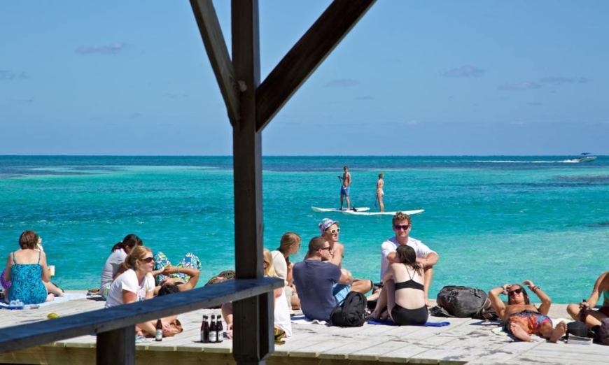 You too could be enjoying the beaches and cool, clear waters of Caye Caulker... Best Beaches for Swimming In Belize Image: Various vacationers sit on the beach and enjoy the water.
