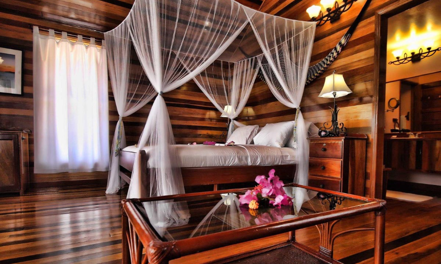 You deserve a rest, swimming is a total body workout after all. Best Beaches for Swimming in Belize Image: A beautiful wooden room features fuchsia flowers on a glass tabletop, and a four poster canopy bed.