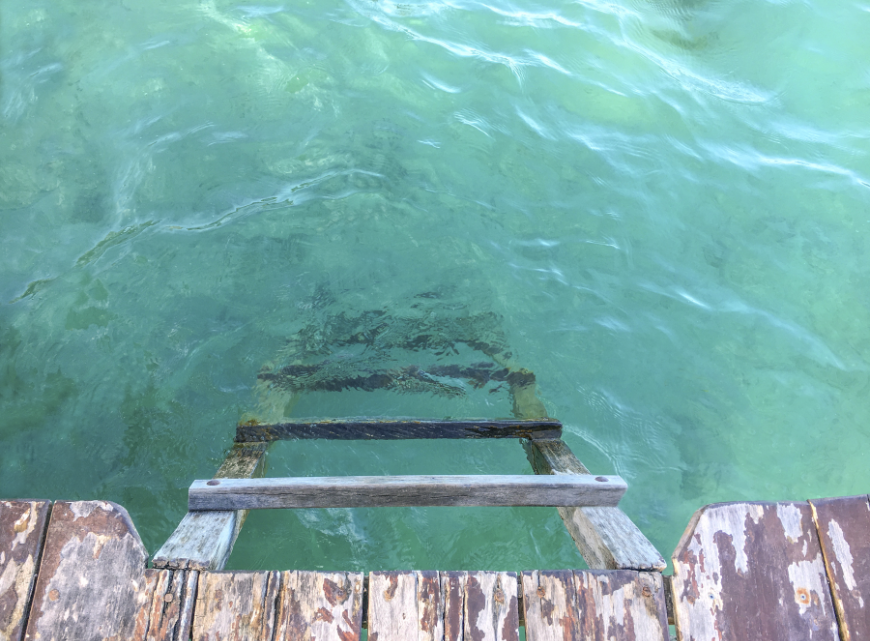 Come on in, the water's fine... Best Beaches for Swimming in Belize Image: A ladder descends from a dock into turquoise water.