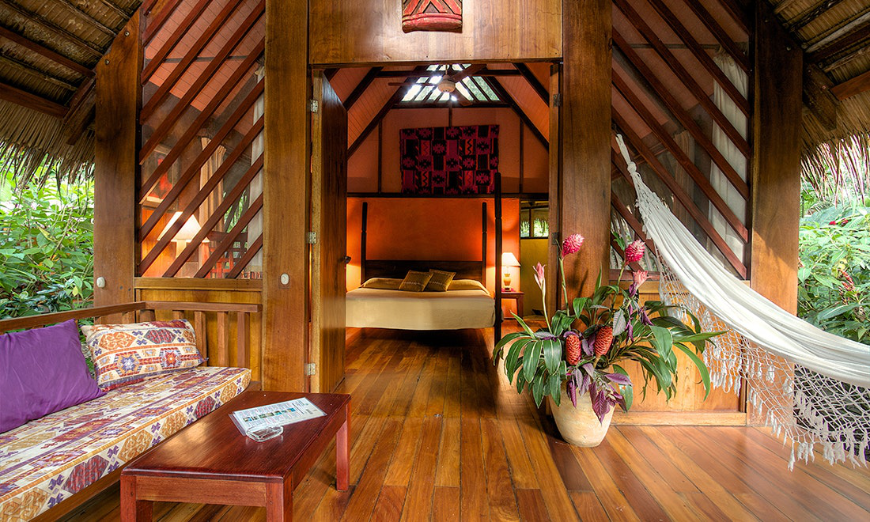 There's an en suite hammock! And it looks so lovely. Best Ecotourism Lodges Image: A lovely rainforest suite has an en suite white hammock, large flowers, and open air thatched roof sitting area.