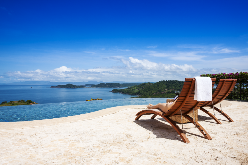 If you want to spend your entire holiday relaxing and reading, you should. Your vacation is just that—YOUR vacation. Best Travel Stories Image: Two chairs overlook an immaculately blue sky and water; bits of greenery are seen from nearby islands, and gentle white clouds hang low in the sky.