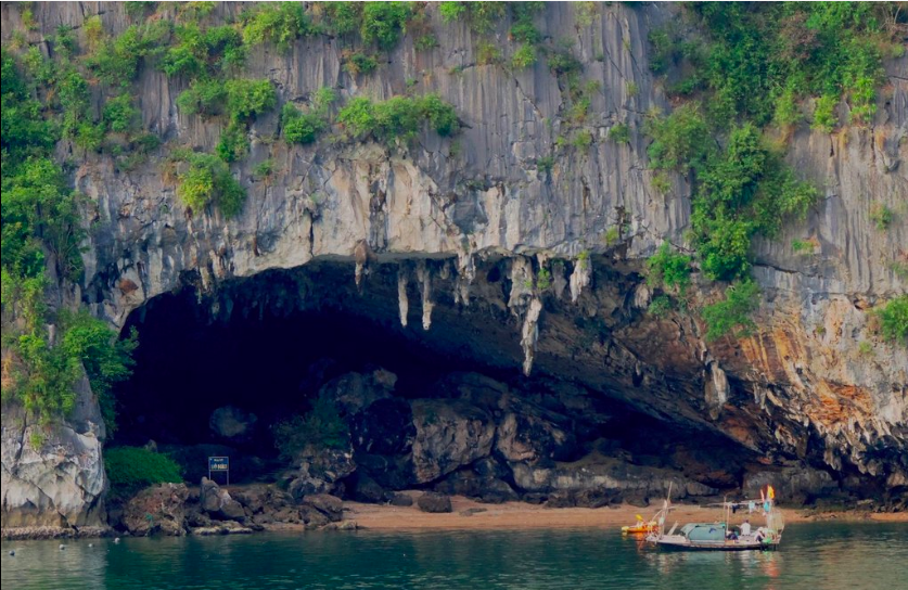 Half the joy of these caving adventures is the journey to get there. Caving in Vietnam Image: A boat and a kayak approach the entrance of Bo Nau Cave.