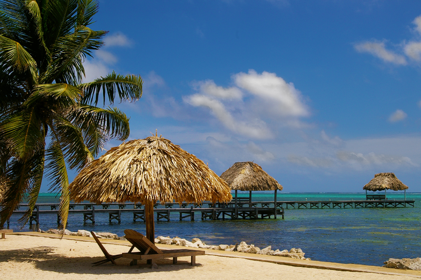 If Belize isn't already on your travel to-do list, then we suggest you promptly add this country. Central America in Winter Image: A lounge chair and thatched umbrella on a tropical beach.