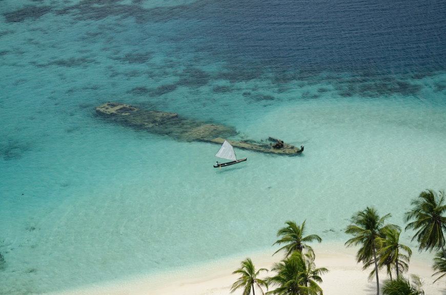 Yes, that DOES appear to be a sunken shipwreck... Central America Islands Image: A sailboat makes its way to a sunken shipwreck just off the coast.