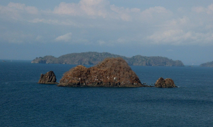 Then again, isn't an island vacation always fun? Central America Islands Image: Green mounds of land sit in the midst of the ocean—foreground and background.