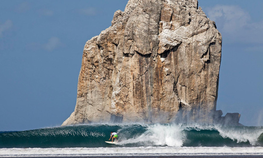 Ride the crest of a wave...if you dare. Costa Rica Activities Image: A surfer rides a cresting wave--some Costa Rica activities are epic, and not for beginners.
