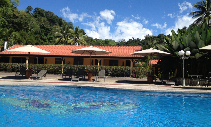 She cares for everyone else; let her be catered to on Mother's Day. Costa Rica Mother's Day Image: A building sits in the background as the lounge chairs, umbrellas, and swimming pool of Cabinas Espadilla take the focus.