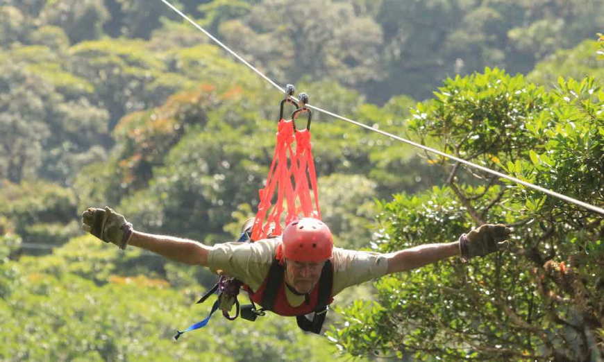 On Costa Rica rainforest tours it's never too late to live out an old childhood dream. Costa Rica Rainforest Tours Image: A gentleman spreads his arms out whilst soaring over the jungle.