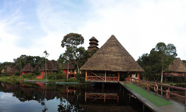 Have a relaxing adventure in the great outdoors. Destination Wedding in Ecuador Image: A pier and peaked thatched roof cabins.