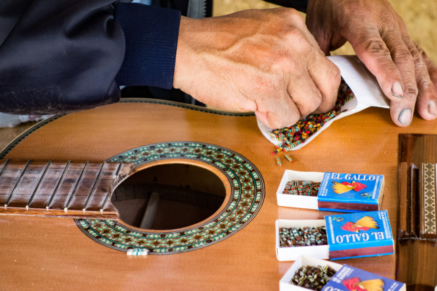 Local musicians and local instruments equal one amazing destination wedding. Destination Wedding in Ecuador Image: An artisan adds a colorful inlay to the guitar he is building.