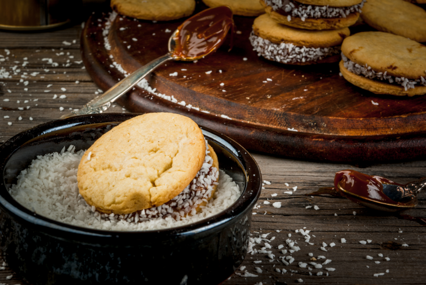 Cookie, dulce de leche, and coconut. What's not to like? Eat In Peru Image: Alfajores, spoons in dulce de leche, and a bowl of shredded coconut.