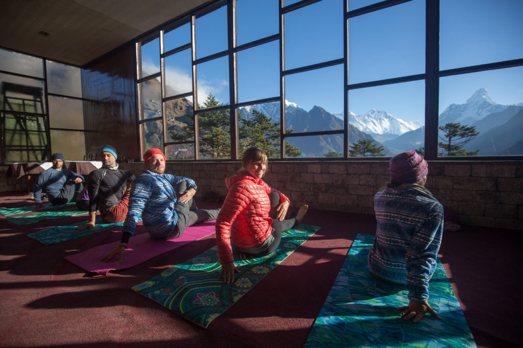 A little yoga, an amazing view, one of the most remarkable holidays you've ever been on. Everest Base Camp Image: Five members of the Everest Base Camp trek do yoga on mats with trees and mountains in the background.