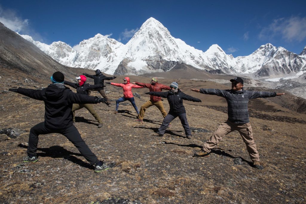 Just a little mountainside yoga—no big deal. Everest Trek Image: Six members of the Everest Base Camp trek are pictured doing the Warrior pose as they follow the moves of their yoga instructor.