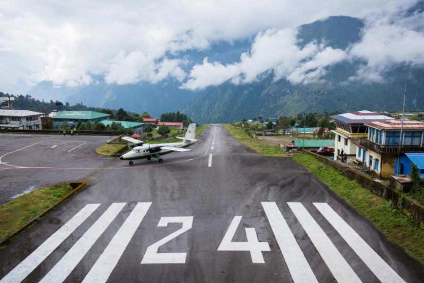A plane lands in Lukla Airport, surrounded by clouds and mountains. Everest Tattoo Image: A plane lands in Lukla Airport, surrounded by clouds and mountains.