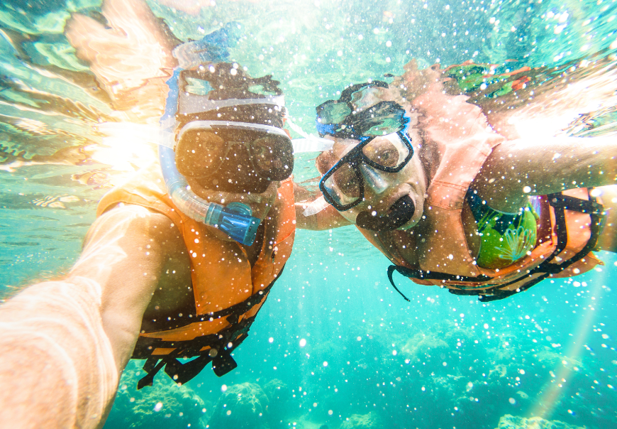 Well, this is certainly an exciting place to strike a pose! family vacations in belize and guatemala image: Two snorkelers take an underwater selfie.