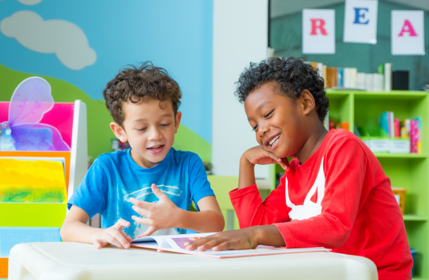 Reading is an activity you can do alone or with a friend. Imagination Bus Image: Two young boys laugh and enjoy a book whilst sitting at a table.