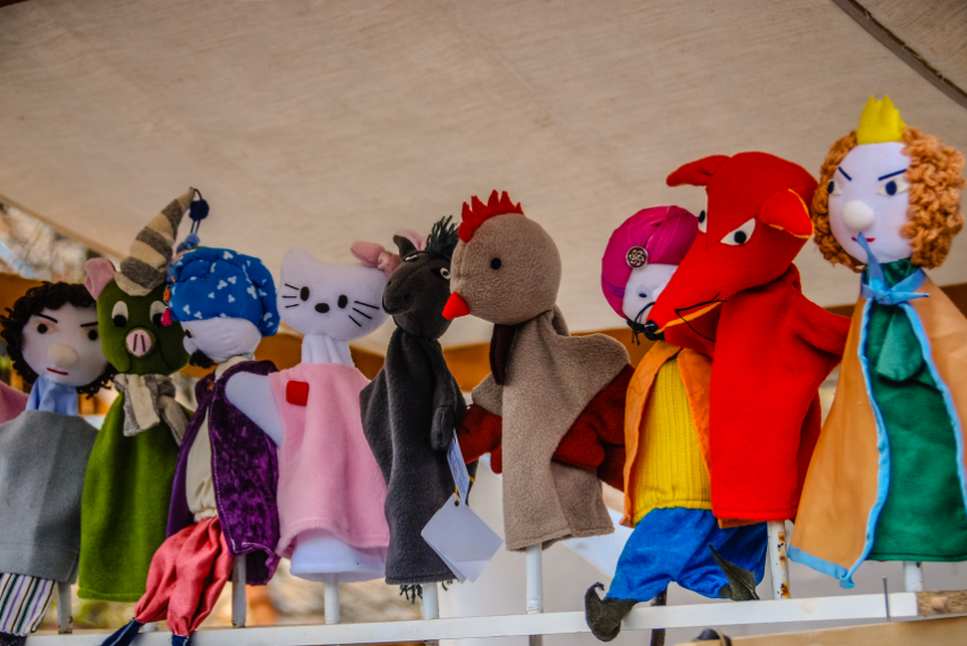 Learning to read can be a hands-on activity, especially when puppet friends help out. Imagination Bus Image: Animal and people hand puppets are lined up waiting for their next performance.