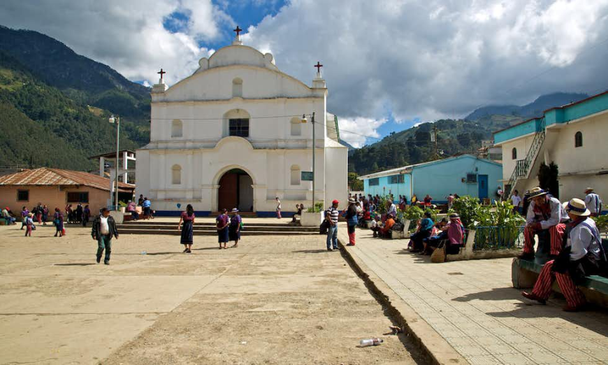 Religion and death have long gone hand in hand. Mayans of Guatemala Image: Locals are scattered before a white church.