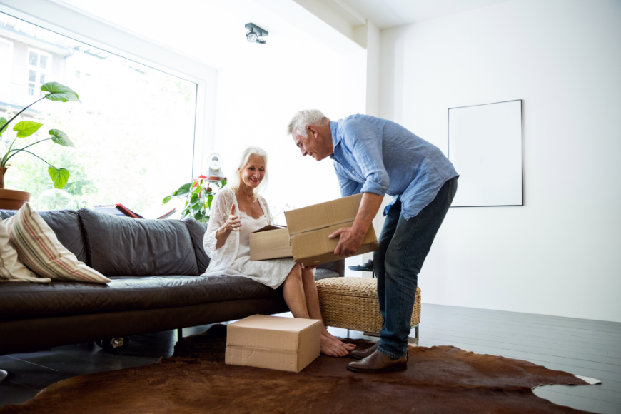 Do suppose unpacking is less annoying when you're in a TOTALLY new city? ...Nah! Moving Abroad Image: A mature silver haired couple unpacks boxes in their home.
