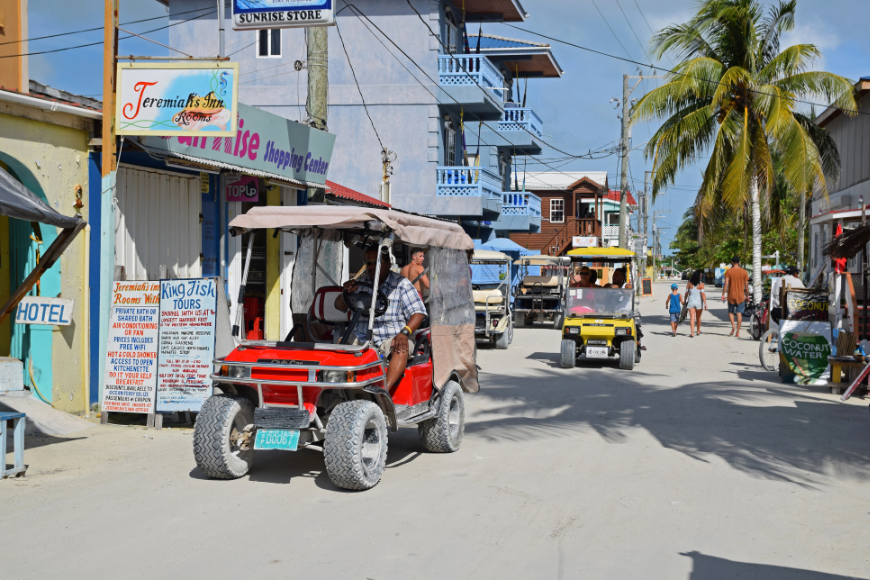 Of all the things to adjust to in your new life, if you're an English speaker, the language won't be one of them. Moving to Belize Image: People walk and ride their golf carts around one of Belize's streets.