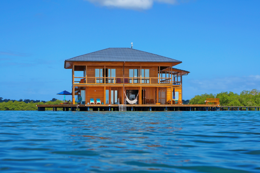 Another day in paradise. Moving To Panama Image: A lovely wooden house is built on stilts over the sea.