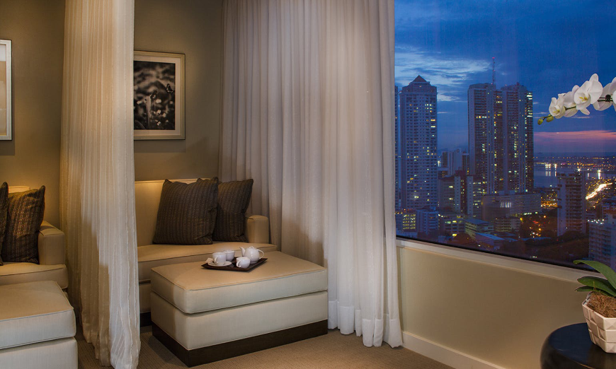 The luxe life in Central America. Moving to Panama Image: A seat in a luxurious room decorated in neutral tones looks out onto an exquisite view of the city.