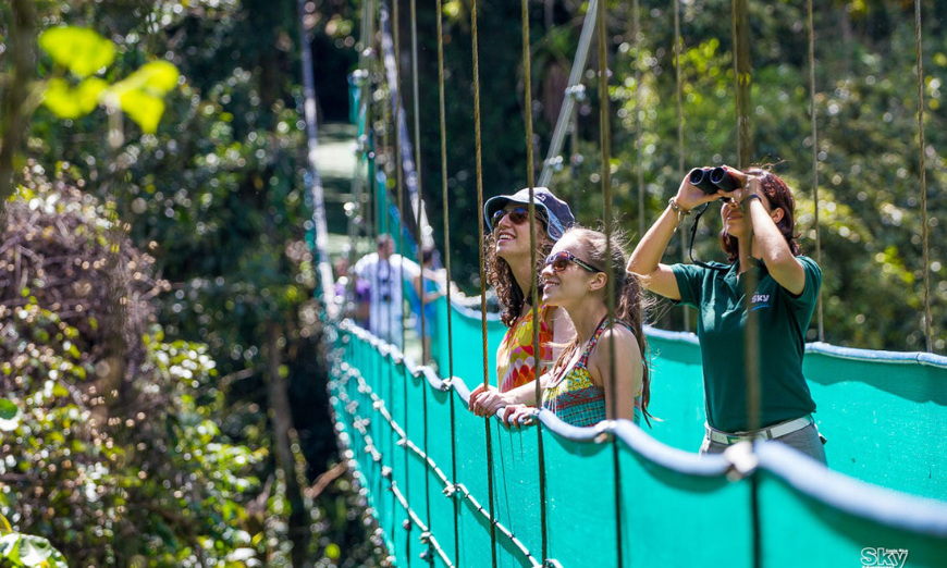 Don't let fear make you miss out on seeing the world's beauty. Is It Safe to Travel in Costa Rica Image: Three people stand on a turquoise suspension bridge.