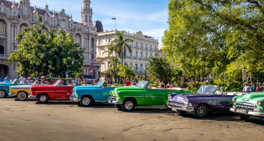They don't make them like this anymore... Salsa Dancing in Cuba: Colorful classic convertibles in yellow, red, blue, green, and purple are parked near classic buildings.