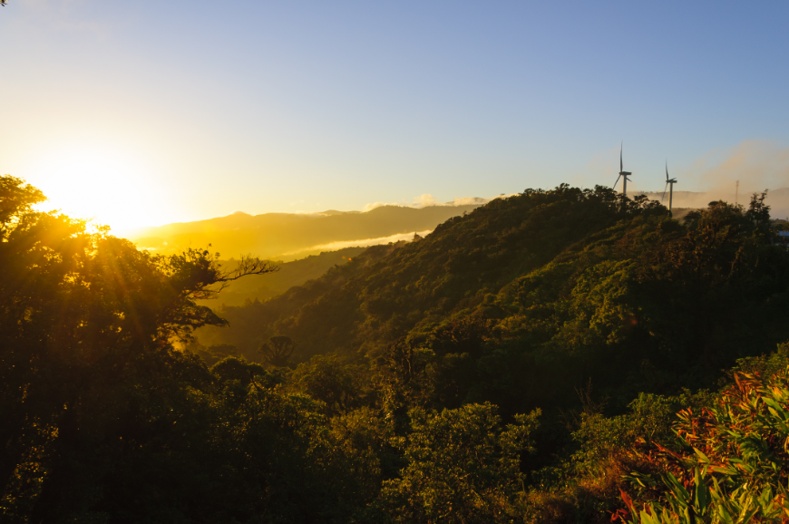 Notice the wind turbines in the background of this lovely sunrise? Sustainable Travel Practices Image: Sunrise over Costa Rica, with wind turbines in the background.