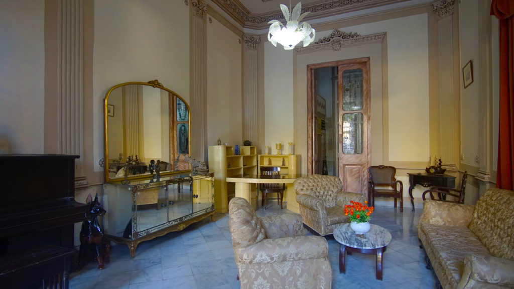 Seeking an authentic Cuban experience? Don't stay in a resort, stay in the home of a Cuban national. Legally Travel To Cuba Image: An interior view of Casa Prado Colonial shows a nicely decorated sitting room, intended to pull together the home's colonial aesthetic.