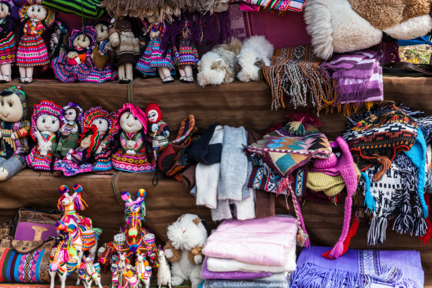Bring home a soft and cozy Peruvian doll for everyone—including yourself! Peru Souvenir Image: A variety of stuffed dolls sit on the shelves of a Peruvian market. These little dolls make excellent (and soft) Peruvian souvenirs.