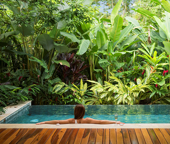 Having a swimming pool to yourself is a unique indulgence everyone should get to experience at least once... Unique Honeymoon Image: A woman sits in a private pool with her arms relaxing on the pool's edge.
