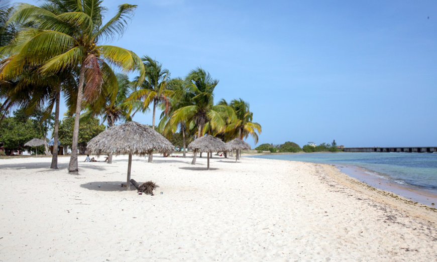 Credit cards will not do you much good on a vacation in Cuba—a country which only accepts cash. Vacation In Cuba Image: A beautiful but empty Cuban beach is dotted with straw umbrellas.