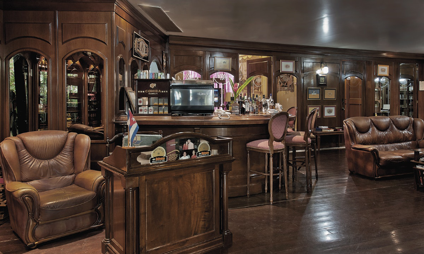 Whilst on holiday, the only thing you should worry about is enjoying yourself. Vacation In Cuba Image: The rich and polished wooden interior of a cigar bar.