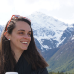 Anywhere Contributor Image: Writer Valerie Stimac smiles with a mountain in the background.